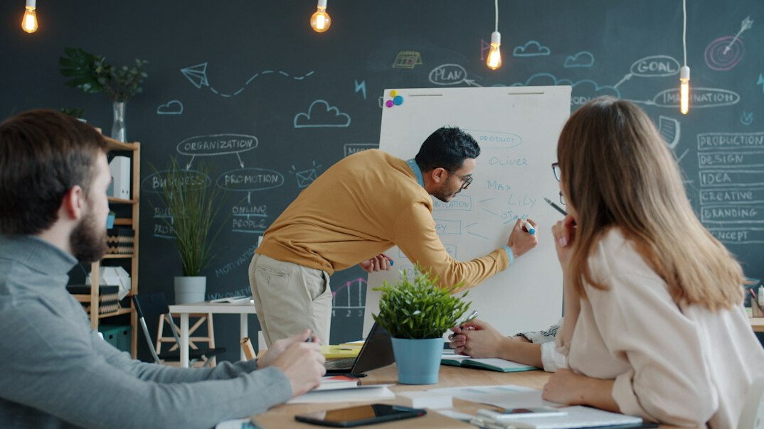 Colleagues collaborating around a table in a bright office